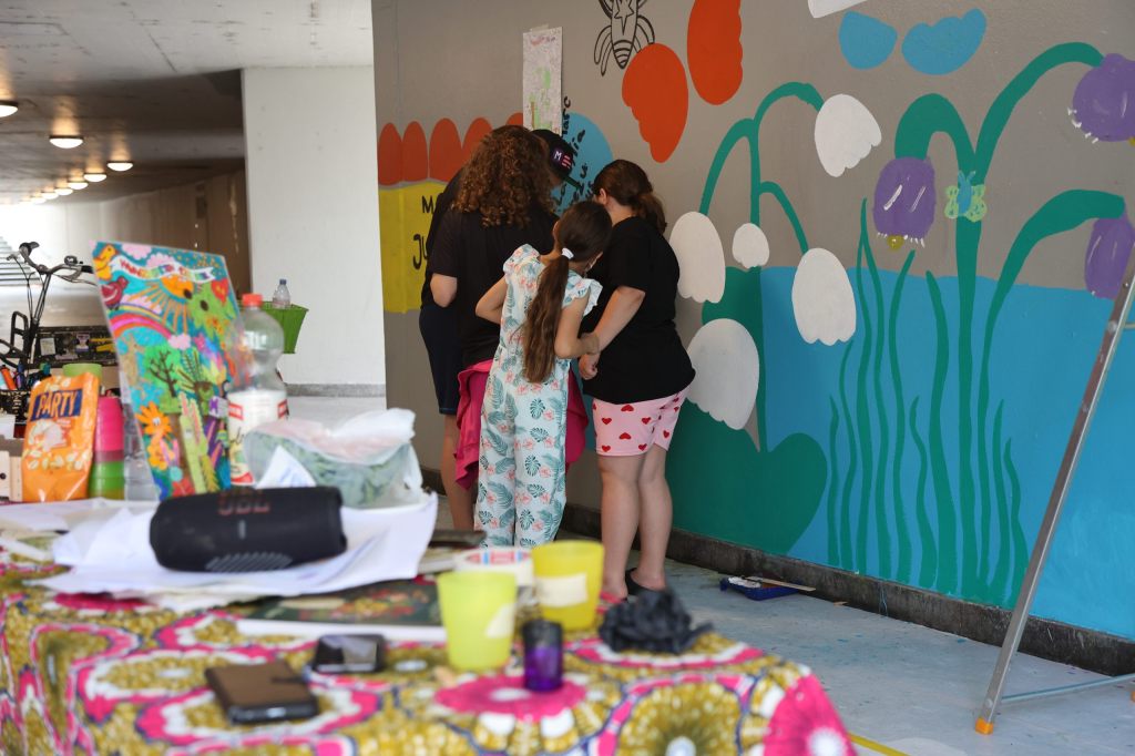 Kinder verwandeln graue Betonmauern in einen bunten Garten