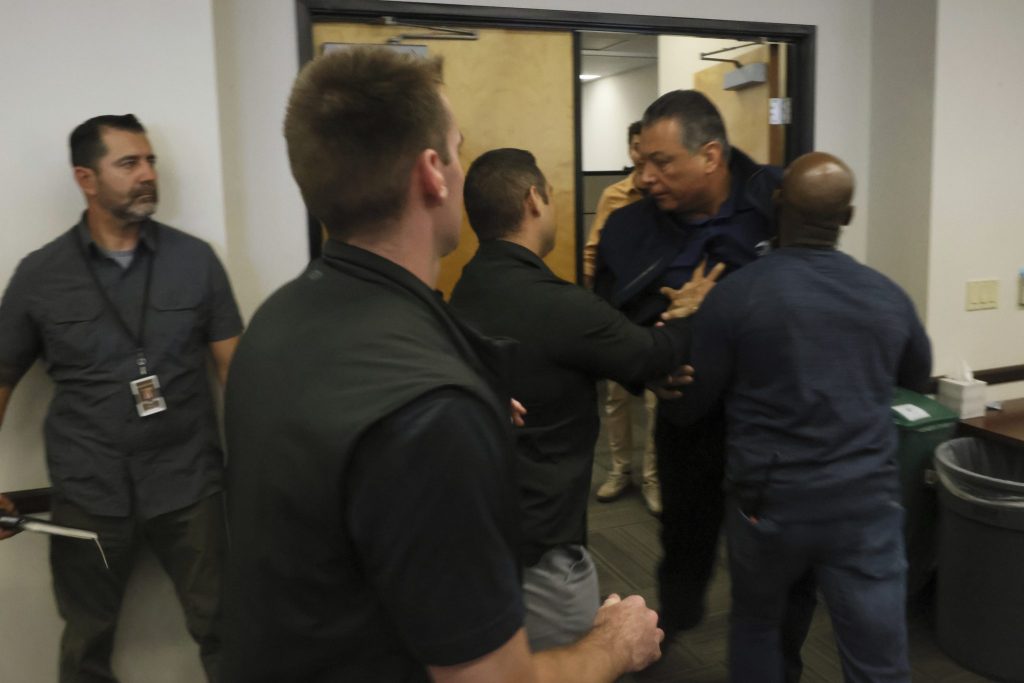 Senator wird während Pressekonferenz aus dem Raum gezerrt und in Handschellen gelegt