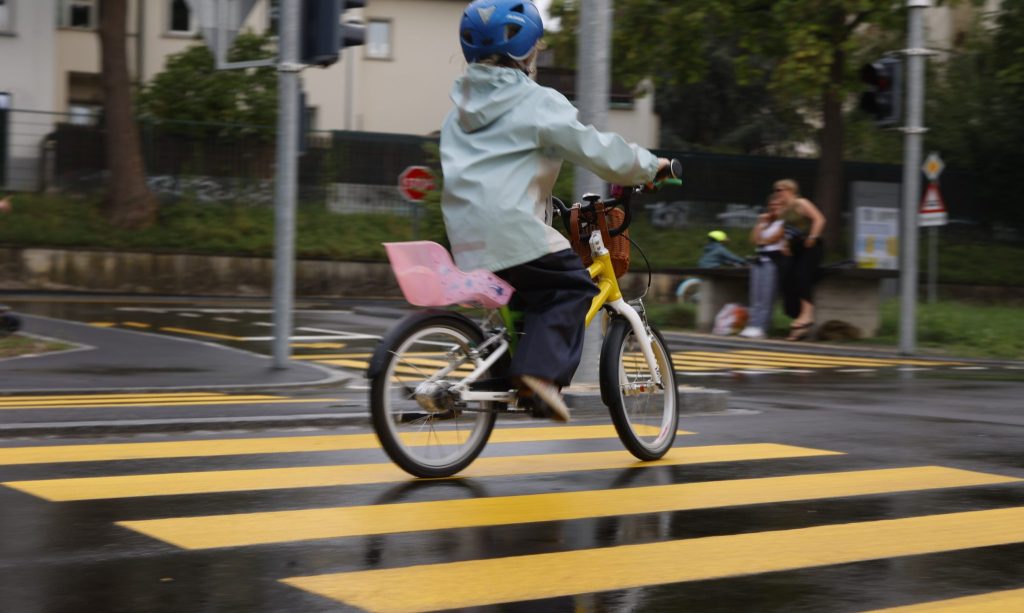 Mit Regenjacke und -hose: Kinder eröffnen den frisch sanierten Verkehrsgarten